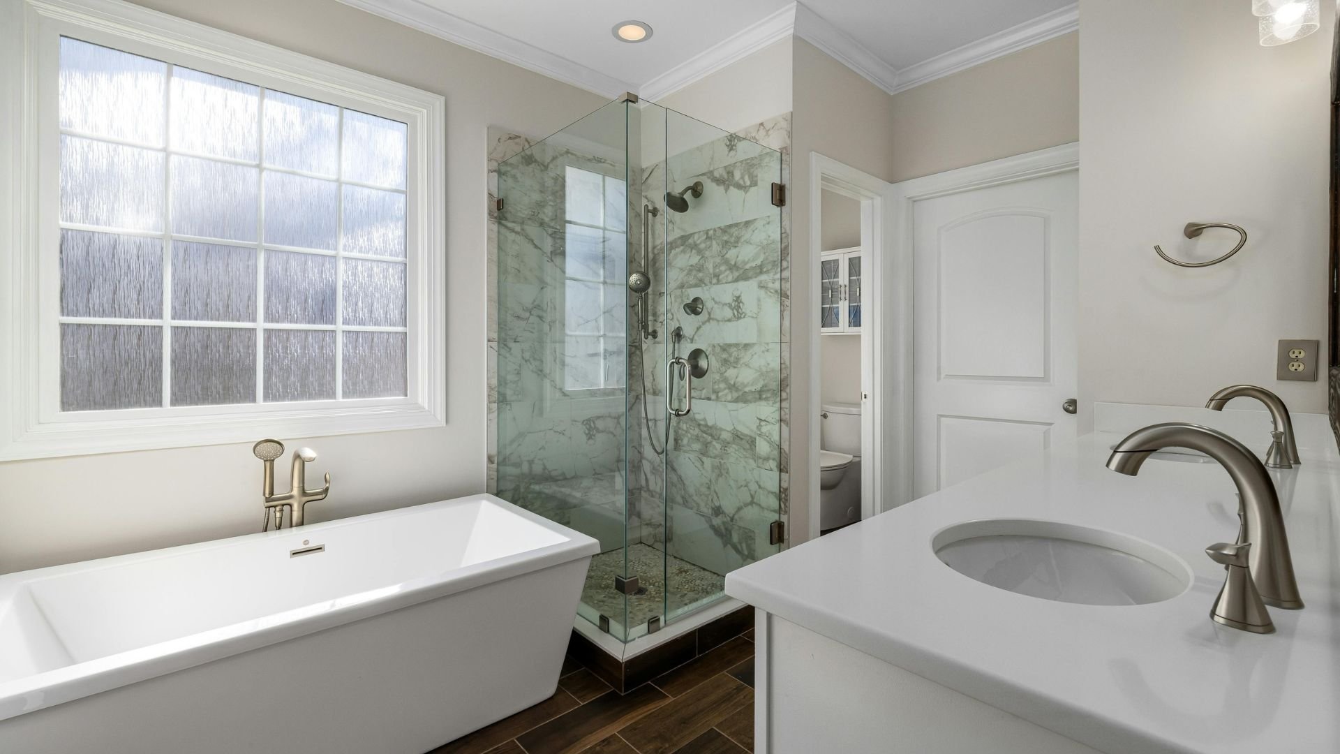 Modern bathroom with marble shower, freestanding tub, and neutral colors
